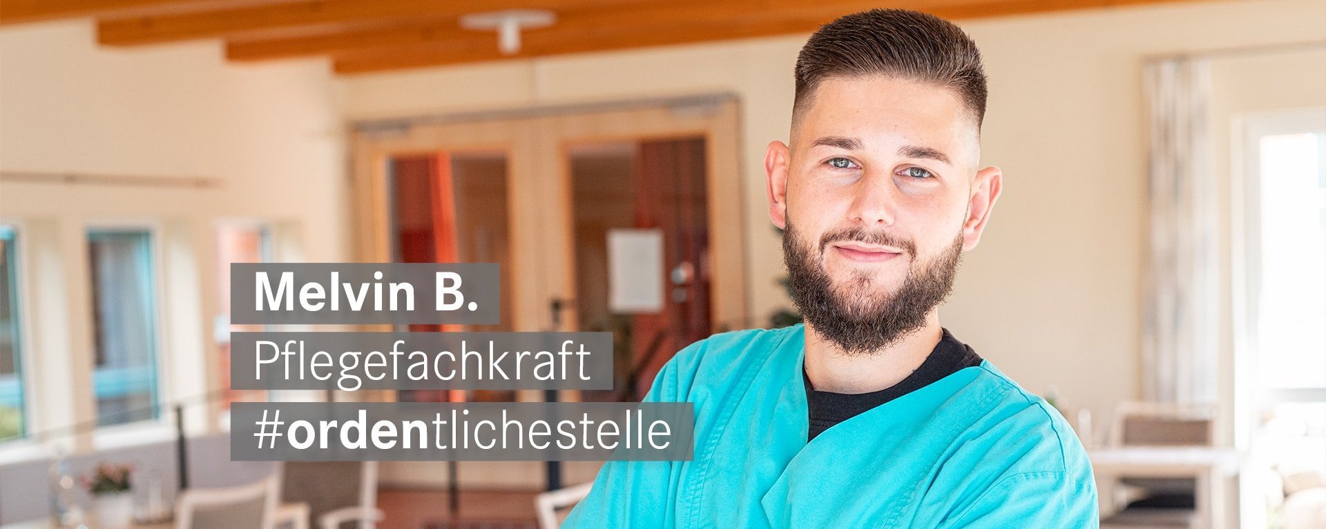 Pflegefachkraft mit Braunen Haaren und blaunen Augen laechelt freundlich in die Kamera